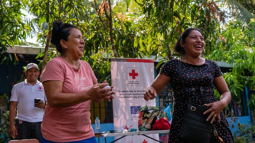 Two women take part in an interactive disaster preparedness exercise during a workshop run by the Salvadoran Red Cross in western El Salvador.