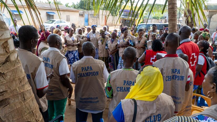 Les "Papas Champions" formés par la Croix-Rouge togolaise pour défendre les droits des femmes tiennent une réunion avec des membres du club des mères à Togblékopé, au Togo.