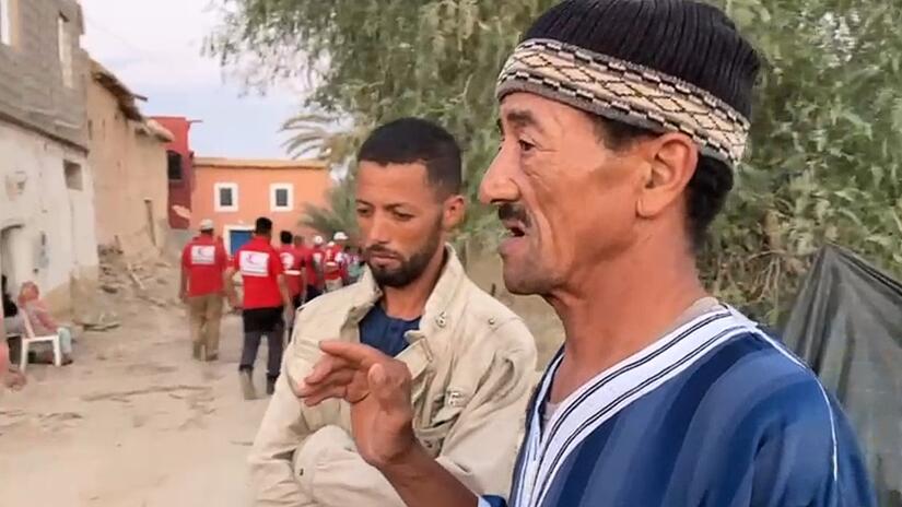 والد سعيد، محمد، يتحدث إلى أحد متطوعي الهلال الأحمر القطري في تمالوكت حول كيفية محاولته إنقاذ أحفاده في أعقاب الزلزال المدمر. 