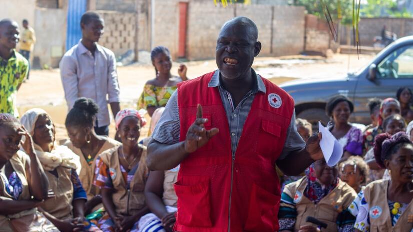Sama Abdou Rahime Arabiou, volontaire de la Croix-Rouge togolaise et président du club des pères de Togblékopé, s'exprime lors d'une session Papa Champion à laquelle participent des femmes et des hommes de la région.