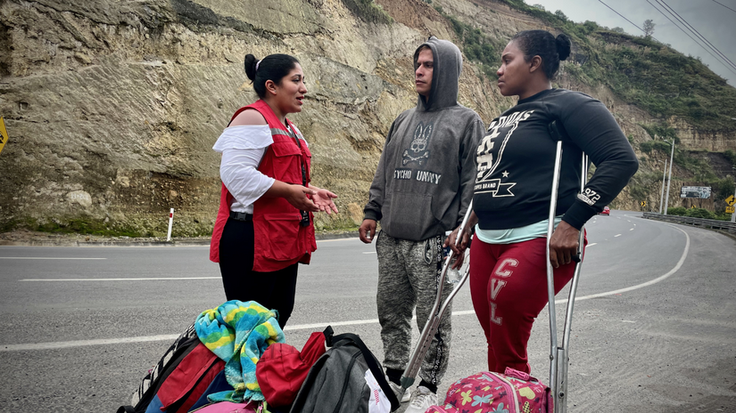 Cristia and Winston receive information from an Ecuadorian Red Cross volunteer.