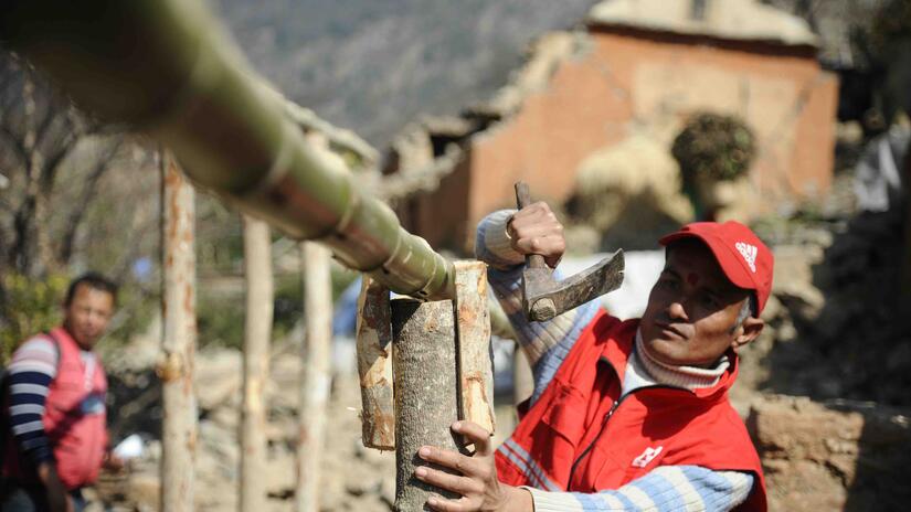 With support from DREF, Nepal Red Cross volunteers provide technical support to build transitional shelters in the Doti district, Nepal, following an earthquake.
