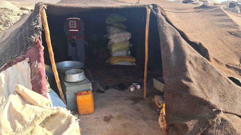 Along with Afghan Red Crescent teams, an IFRC staff member visits the makeshift shelter of a family that lost their home to the quake.