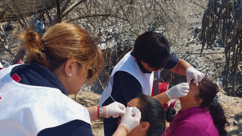 Personal voluntario de la Cruz Roja chilena presta primeros auxilios a las personas afectadas por los incendios forestales.