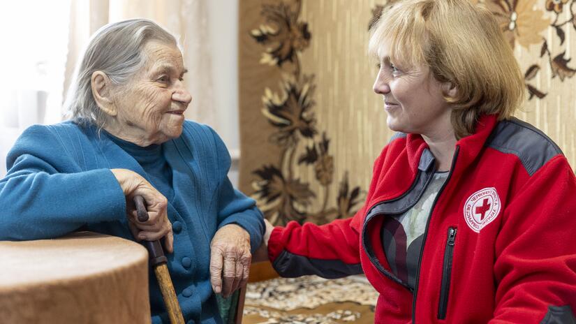 Ukrainian Red Cross social worker Tetyana Kereya comforts 92-year-old Maria Basok in her home in Lanivtsi, Ternopil oblast