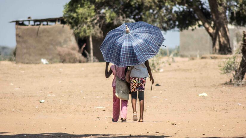 Ces deux enfants, qui marchent sous un parasol dans une région du Mozambique touchée par la sécheresse, illustrent les solutions auxquelles les gens ont souvent recours pour se protéger des fortes chaleurs. Les vagues de chaleur étant de plus en plus fréquentes et intenses, l'IFRC estime qu'il faut faire davantage pour aider les populations à s'adapter.