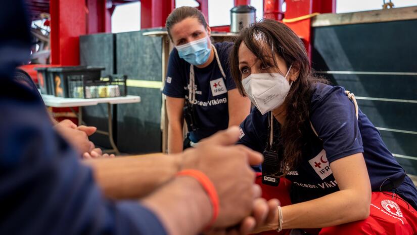 Sara Mancinelli listens to the story of a recently rescued migrant aboard the Ocean Viking.