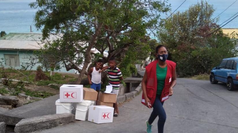 Rhea Pierre, disaster preparedness and climate-crisis coordinator for IFRC in the English and Dutch speaking Caribbean, drops off basic living supplies following the eruption of the La Soufrière volcano in St. Vincent and the Grenadines. 