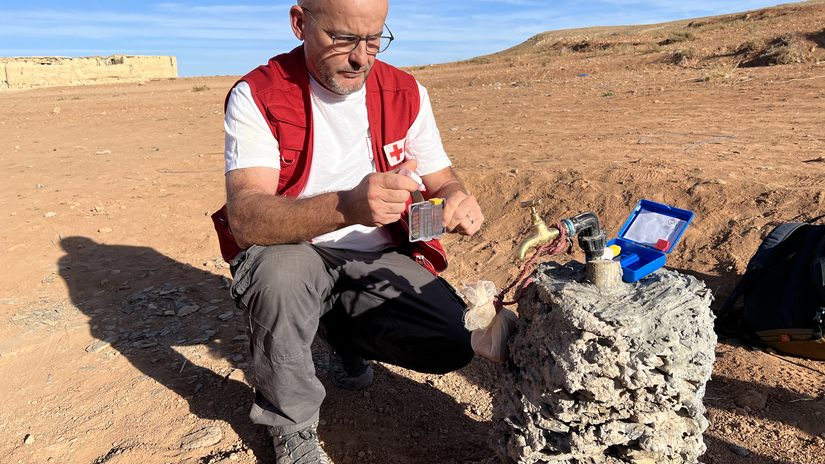 El delegado de agua, saneamiento e higiene de la IFRC, Gregory González, comprueba la calidad de un punto de agua recién instalado en una remota aldea marroquí, tras el terremoto de septiembre de 2023.