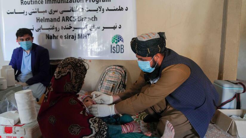Un membre de l’équipe mobile du Croissant-Rouge afghan vaccine un nourrisson lors d’une campagne de vaccination en juillet 2023.