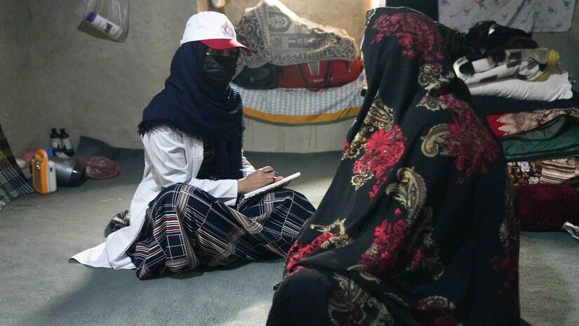 Les femmes constituent une grande partie des équipes des cliniques mobiles de santé et elles jouent un rôle très important, notamment en ce qui concerne la santé des femmes dans les communautés éloignées. Ici, une employée de l'équipe mobile de santé du Croissant-Rouge afghan consulte une femme dans la province de Helmand.