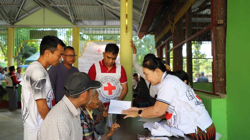 Dr. Chaw Khin talks with people impacted by Cyclone Mocha in 2023 during a cash distribution aimed at helping them get back on their feet after the storm.