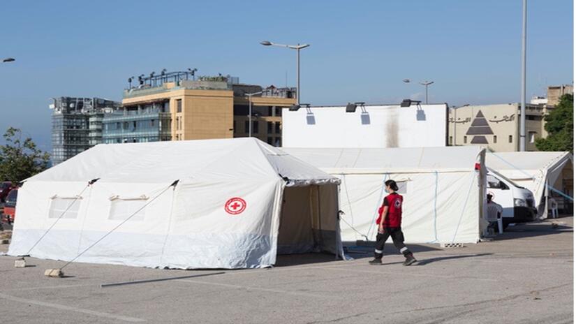 Members of the Lebanese Red Cross Humanitarian Service Point team that responds to shipwrecked migrants stand outside their response vehicles.