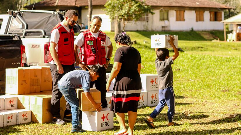 Voluntarios de la Cruz Roja Brasileña entregan cajas de artículos de emergencia a la comunidad indígena de Goj Kusug en Rio Grande do Sul, Brasil, una comunidad afectada indirectamente por las inundaciones.