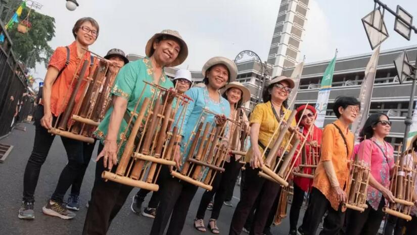 Portant des instruments de musique traditionnels indonésiens, des personnes défilent dans le cadre de la « Journée sans voiture » dans la ville de Surabaya, en Indonésie. La Croix-Rouge indonésienne a participé à cet événement pour sensibiliser la population aux dangers des vagues de chaleur.