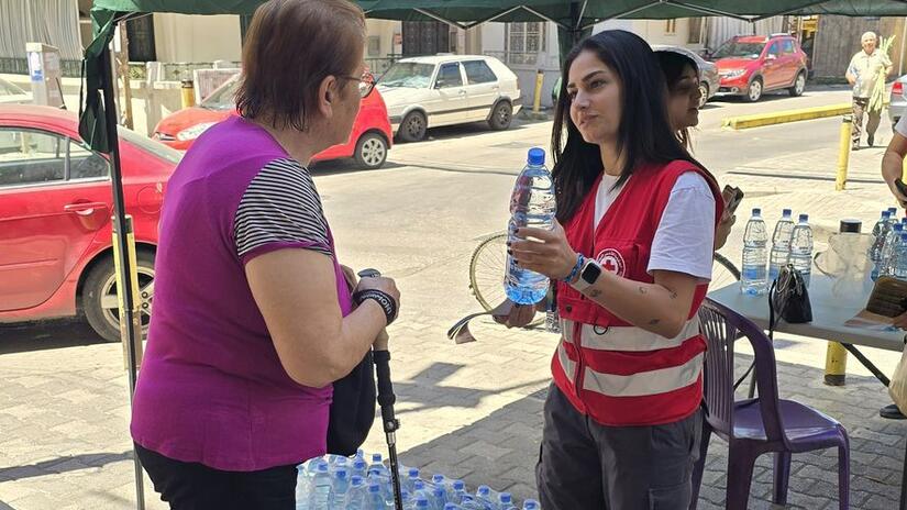 A Lebanese Red Cross volunteer shares a water bottle and valuable information about protection from heatwaves. It’s part of a comprehensive plan to get ahead of heatwave season.