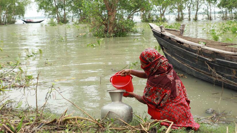 Une femme puise de l'eau salée dans l'estuaire d'une rivière, seul recours après que le cyclone Remal a détruit les sources habituelles d'eau potable. L'accès à l'eau potable est essentiel, car plus de 20 000 points d'eau et plus de 134 000 latrines ont été endommagés par la tempête.