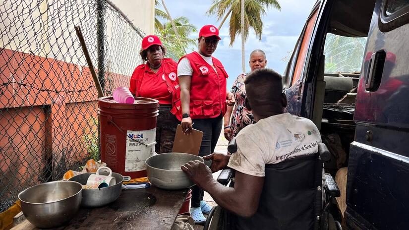 Personal voluntario de la Cruz Roja de Granada visita a un residente local para evaluar sus necesidades y proporcionarle suministros necesarios como lonas, kits de higiene y limpieza, bidones y bolsas de comida, entre otras cosas.