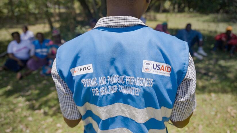 ‘Epidemic and pandemic preparedness for healthier communities’ - the unmissable words on the back of a Community Health Promoters' vest as he addresses people in Kipajit.