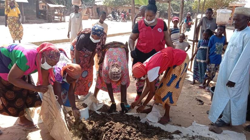 Nigerian Red Cross volunteer Saratu Aboki works with women to make compost they can use in their gardens.
