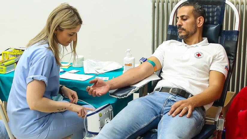 Volunteer Mohammed Alburai gives blood in Slovenia, where he now works as a Red Cross volunteer helping fellow refugees.