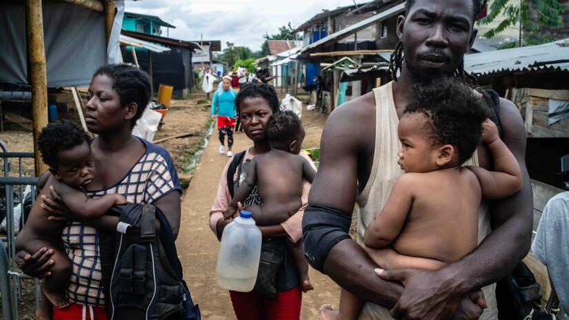 En esta imagen, un grupo de personas de Haití camina por las calles de Bajo Chiquito, Panamá, una de las primeras comunidades que la gente alcanza después de cruzar el Darién.