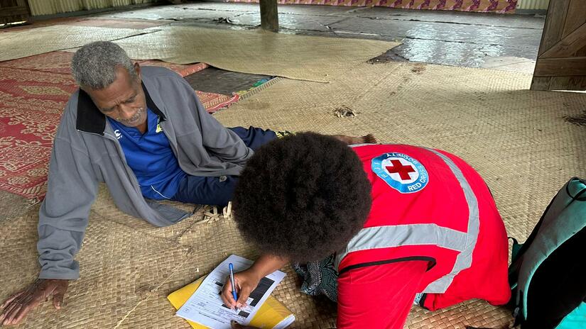 A Fiji Red Cross volunteer talks to a local resident as part of a Dengue Fever awareness campaign.
