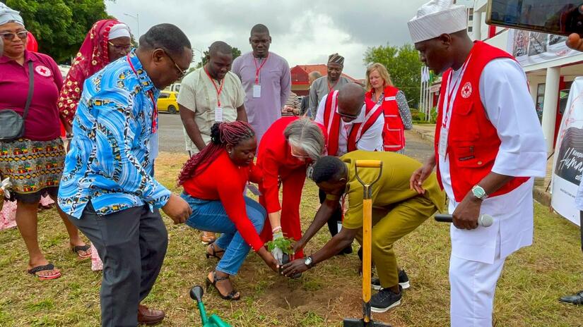 Along with IFRC president Kate Forbes, Ghana Red Cross volunteer Abudi Razak plants a tree as part of climate-change adaptation projects he has organized for young people in Ghana.