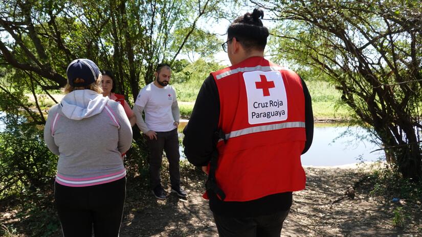Personal de la Cruz Roja Paraguaya y de la IFRC hablan con Ruth, una mujer local de Barcelona II, para identificar las principales necesidades de la comunidad.