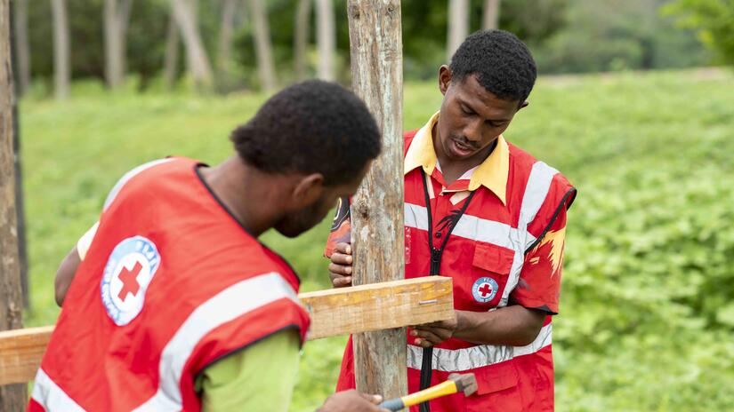 Fiji Red Cross youth volunteers build a rubbish bin as part of efforts to keep waterways clear of debris that might cause blockages and worsen the impacts of floods.