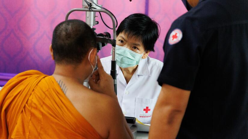 Ophthalmologist Dr Uraiwan Tinnungwattana conducts an eye exam as part of her work for the Medical Service Unit of the Thai Red Cross Society, where she has pioneered efforts to bring eye care to marginalized communities.