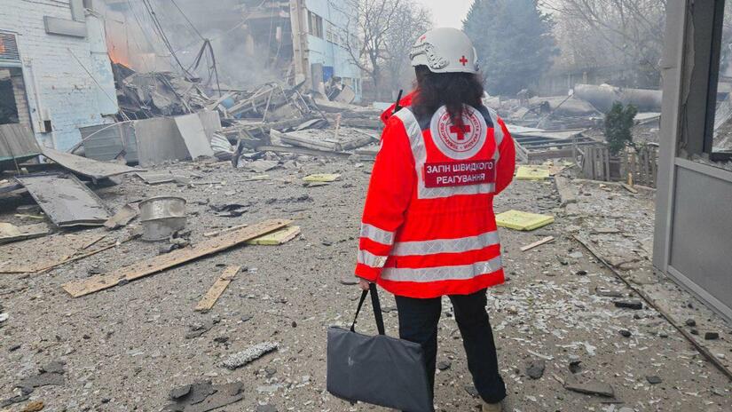 Ukraine Red Cross volunteer inspects damage after a bombardment.