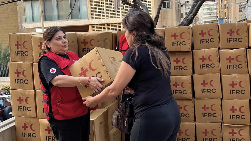 Una voluntaria de la Cruz Roja Libanesa distribuye suministros de socorro proporcionados en parte gracias a un llamamiento de emergencia de la IFRC.