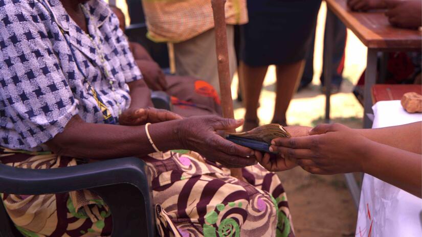 A woman receives cash as part of a cash assistance programme being carried out in Chinkankata, near Zambia’s southern border with Zimbabwe.