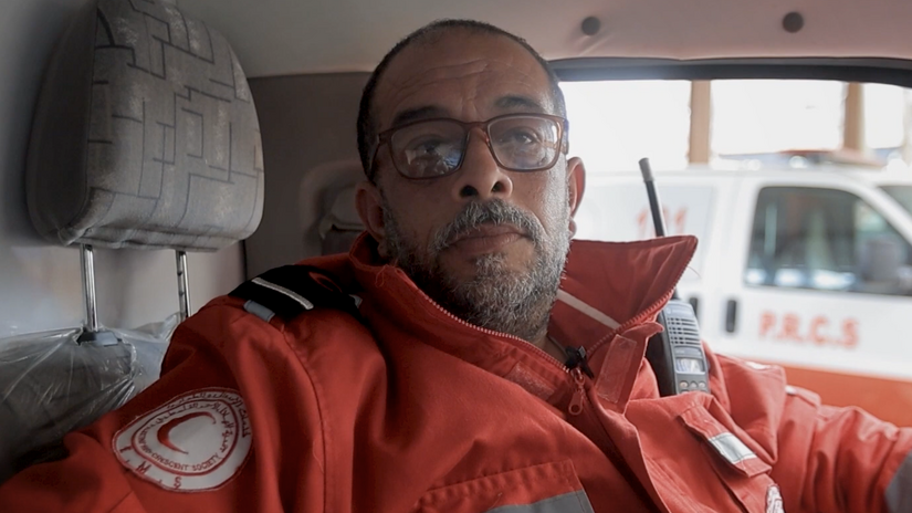 Palestine Red Crescent paramedic Kamal Ahmad sitting in the driver's seat of a Red Crescent ambulance.