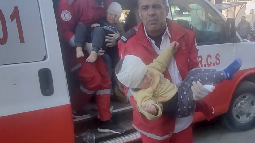Palestine Red Crescent volunteer Jihad Mansour carries and injured child from an ambulance into the hospital.