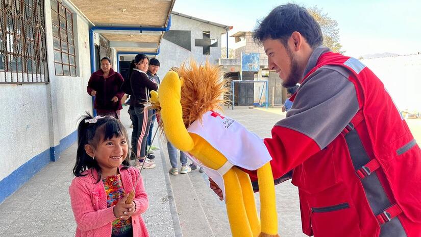 A volunteer for the Guatemalan Red Cross performs at a local school as part of a community theatre activity that teaches children about disease prevention.