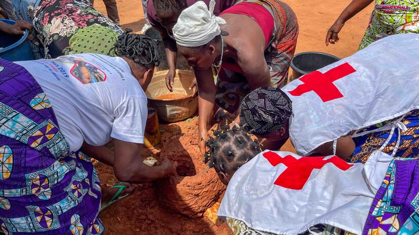Members of Mothers’Club in Benin work together to building a fuel-efficient stove using locally available clay.