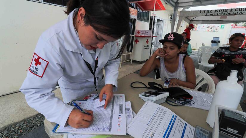 A staff member of the Ecuadorian Red Cross begins the process of offering free medical and psychological care to a young migrant in Huaquillas, Ecuador. Hunger, malnutrition, dehydration, stress and various illnesses and ailments are some of the issues facing people on the move.