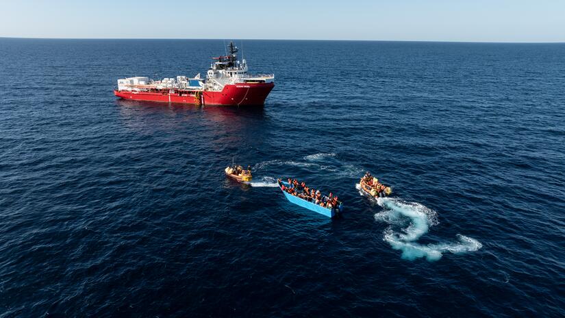 Crewmembers from The Ocean Viking use small motorboats to rescue migrants from a boat in distress.