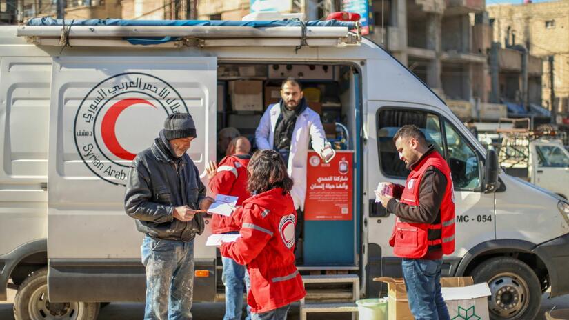 As part of a blood donation campaign launched in February 2025, a Syrian Arab Red Crescent volunteer hands out informative flyers to raise awareness about the urgent need for blood donors. 