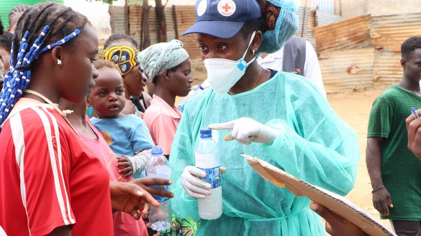 An Angola Red Cross volunteer explains how to use water safely and follow best hygiene practices in order to avoid catching cholera.