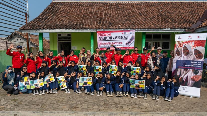 Schoolchildren from MTs MII Cidangiang school in Saruni village smile and make the hand gesture for the CP3 programme after participating in a dengue awareness session led by Indonesian Red Cross volunteers in July 2024.