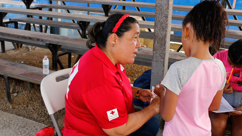 Grettel Pérez, directora nacional del cuerpo de socorristas de la Cruz Roja Panameña, habla con una niña durante la operación de respuesta a las inundaciones del pasado noviembre en Pacora, Panamá Este.