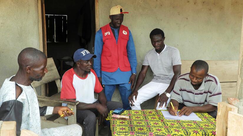 A Guinea Red Cross volunteer with the Community Epidemic and Pandemic Preparedness Programme (CP3) helps villagers in Kabayaba develop a plan for finalizing the health centre and securing resources from local health authorities.