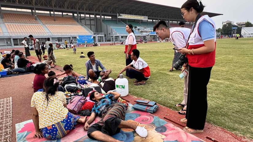 Myanmar Red Cross volunteer speaks with people displaced by the powerful, 7.7 magnitude earthquake that struck central Myanmar on 28 March, 2025.