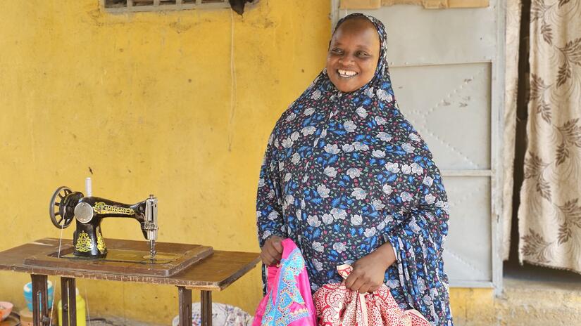 Standing in front of her house, Souraya explains to Cameroon Red Cross volunteers how the Kodek Mothers' Club has changed her life.