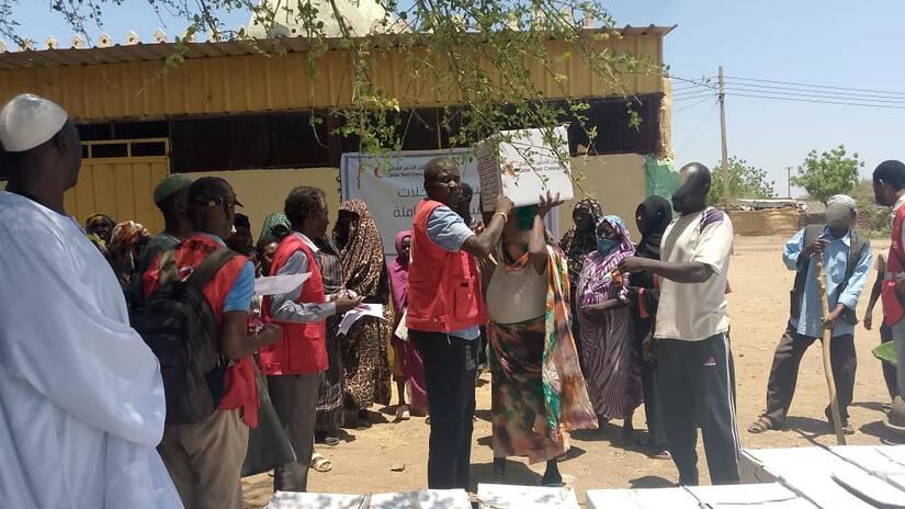 In Sennar State, Sudanese Red Crescent volunteers distribute food baskets for people displaced by fighting. The food packages were provided in cooperation with the Qatar Red Crescent.