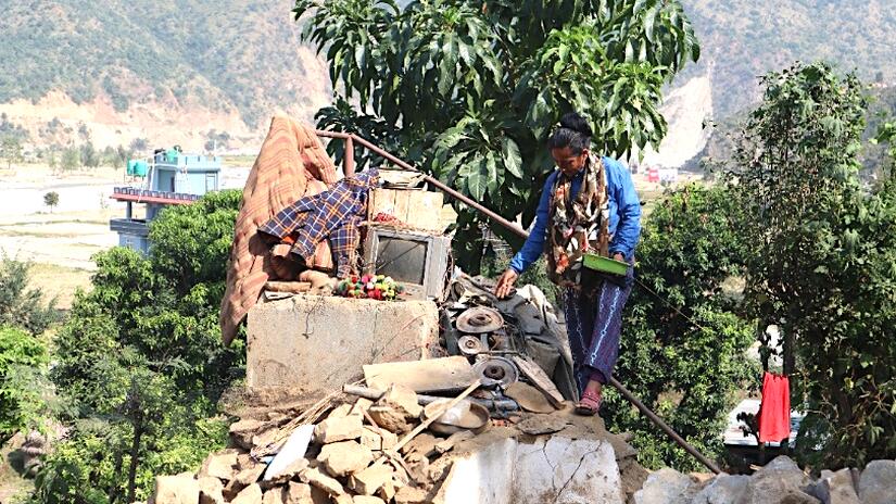 A woman searches through the rubble so see if she can salvage belongings that were swept away by the floods.
