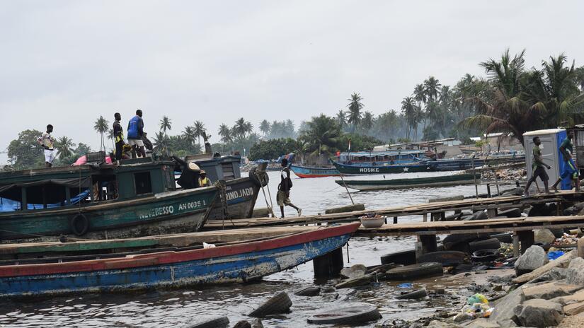 People board a small ferry at the shoreline of Vridi Ako, a town of more than 19,000 people where people often travel back and forth from across West Africa, including Ghana, Liberia, Mali, Sierra Leone, Guinea, and Senegal. 